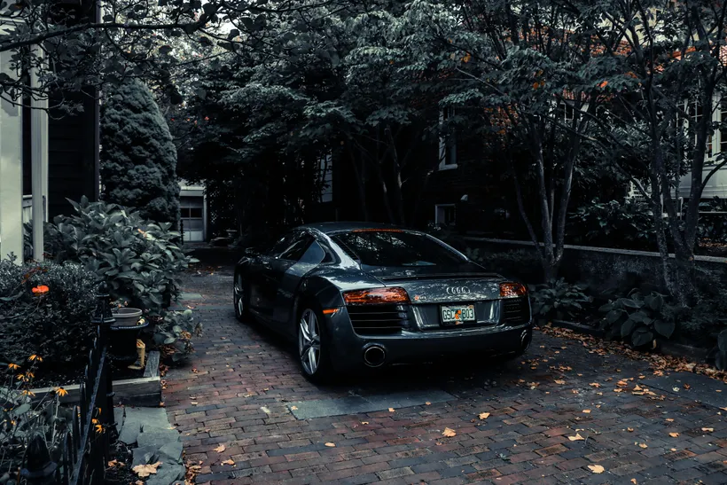 Audi R8 parked on a tree-lined driveway